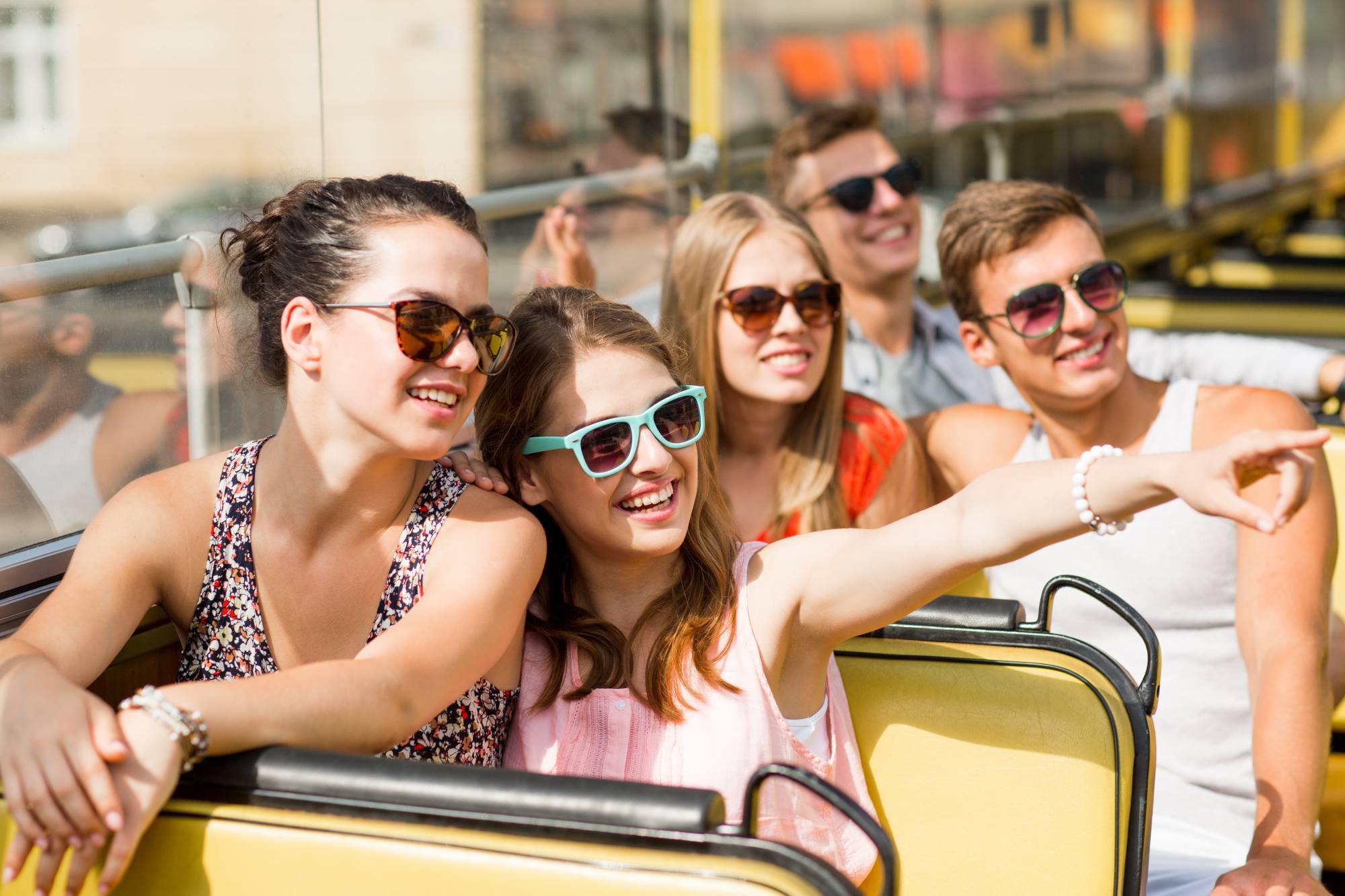 Konzept für Freundschaft, Reisen, Urlaub, Sommer und Menschen - Gruppe lächelnder Freunde, die mit dem Tourbus reisen
